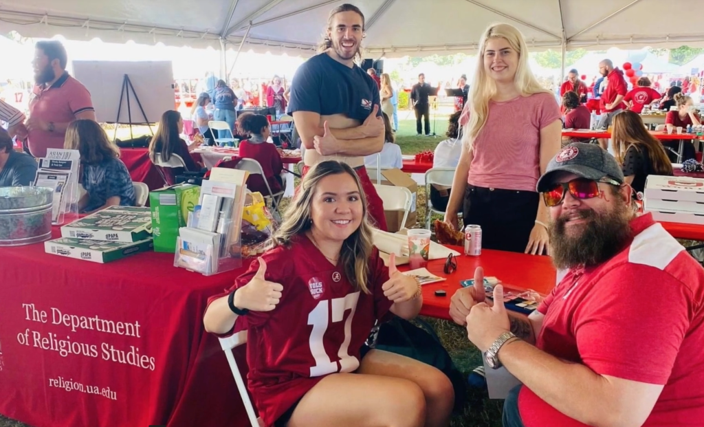 Four REL students at the 2021 homecoming tent