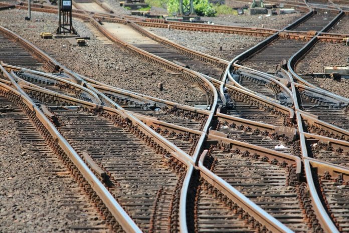 A series of diverging railroad line switches in a switchyard.
