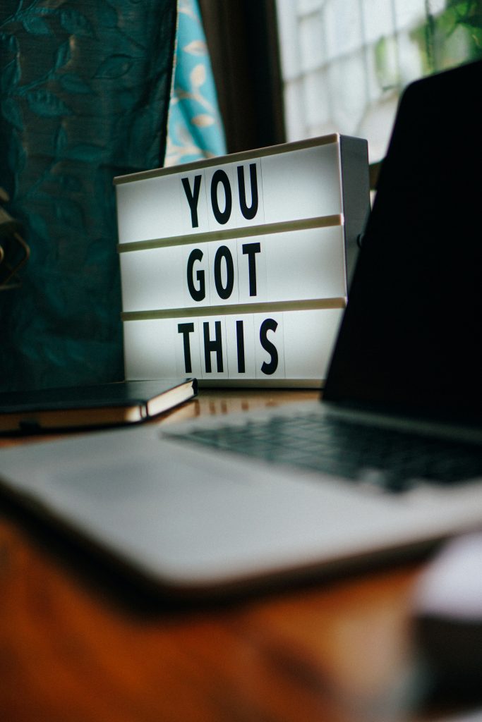 A sign beside an open laptop that says "You got this."