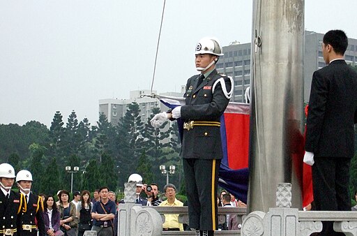 Uniformed military member with white gloves performing the lowering of Taiwan's flag