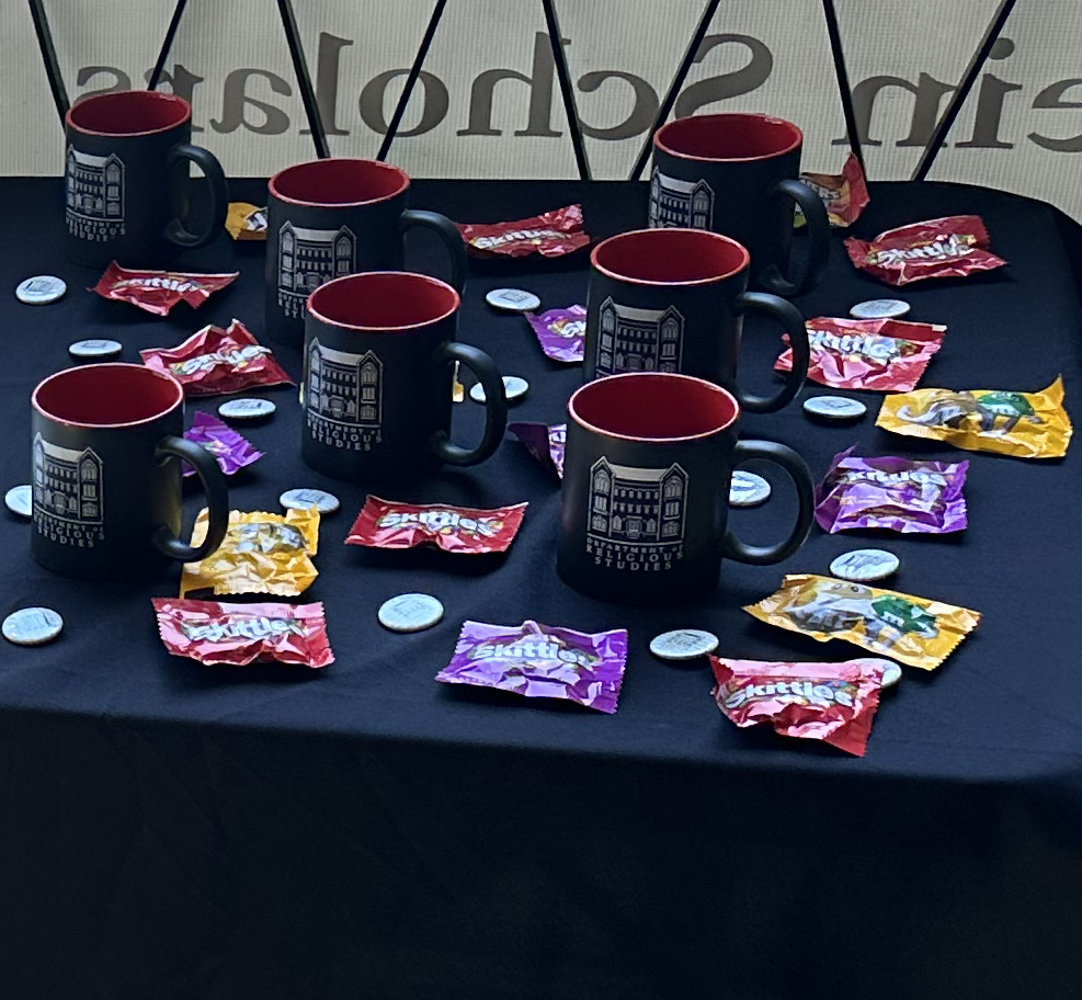 Photo of black mugs and white buttons on a black tablecloth