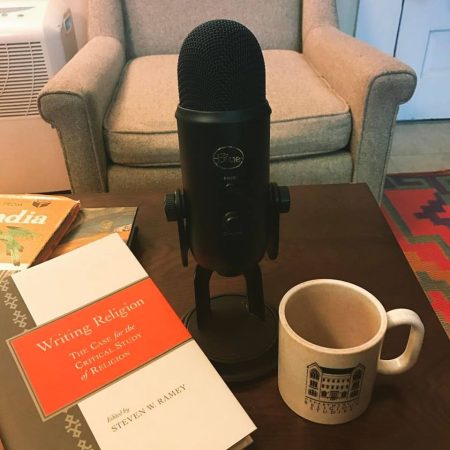 image of microphone, coffee mug, and book on a table