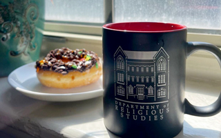 religious studies coffee mug resting in a windowsill